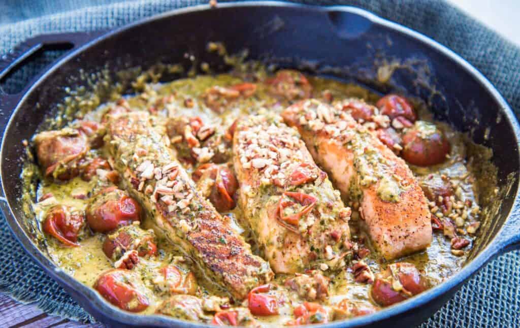 This is a picture of pesto salmon and tomatoes in a pan. The Hangry Economist.