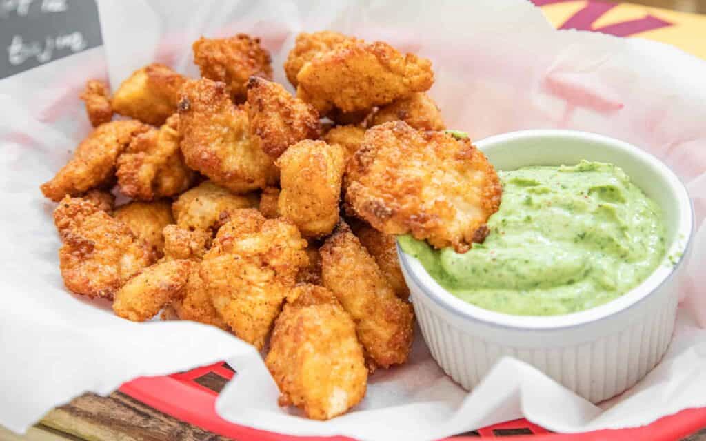 This is a picture of chicken nuggets with avocado lime dip.