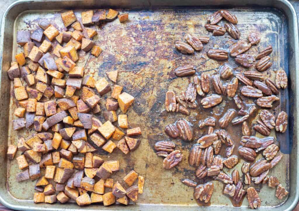 This is a picture of sweet potatoes and pecans on a baking sheet.