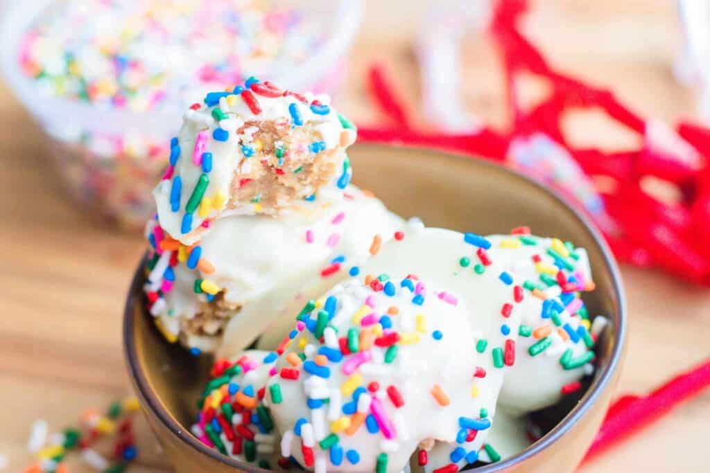This is a picture of confetti cookie dough bites with a bite out of one.