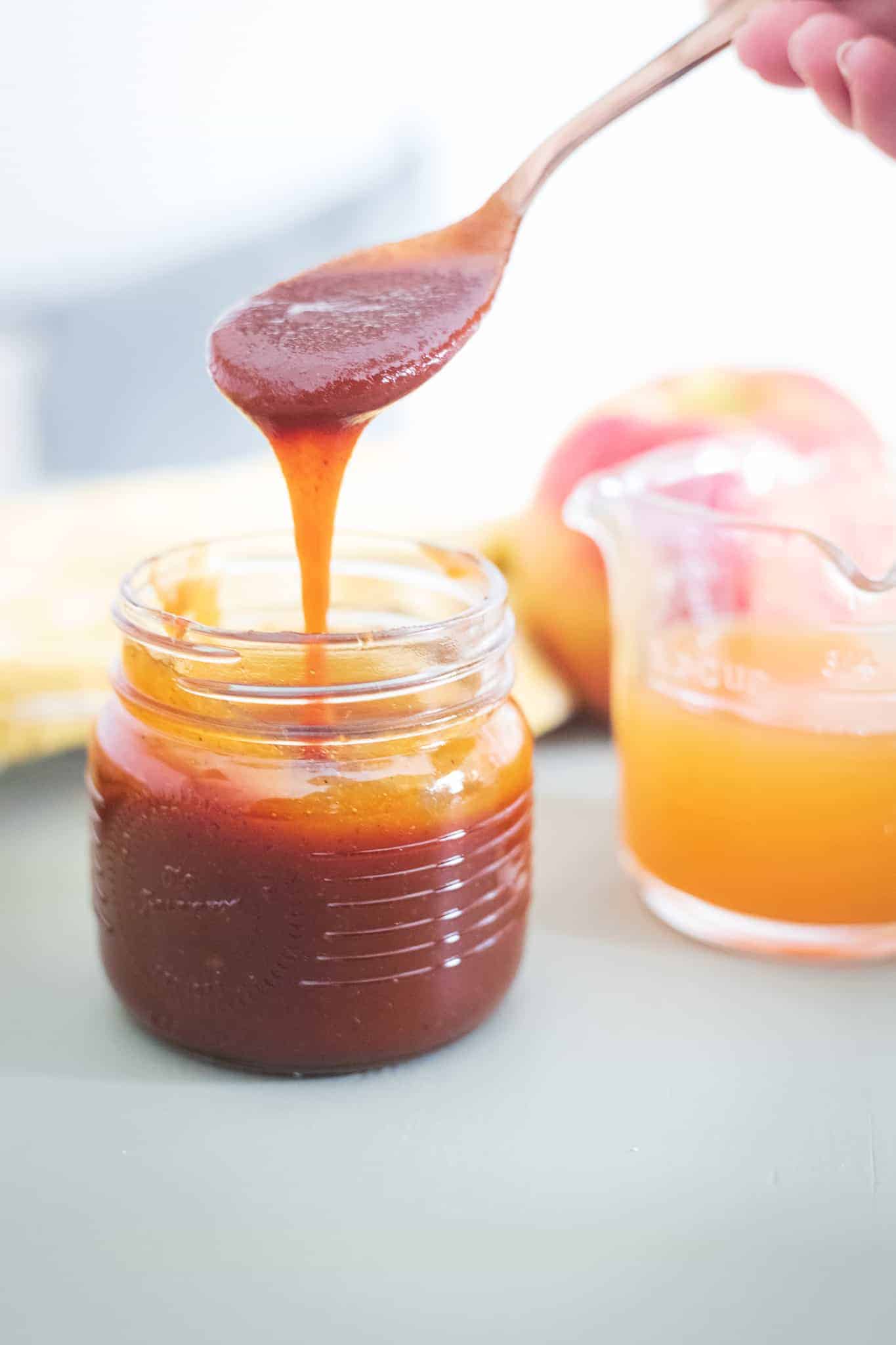 Apple cider BBQ sauce dripping off a spoon.