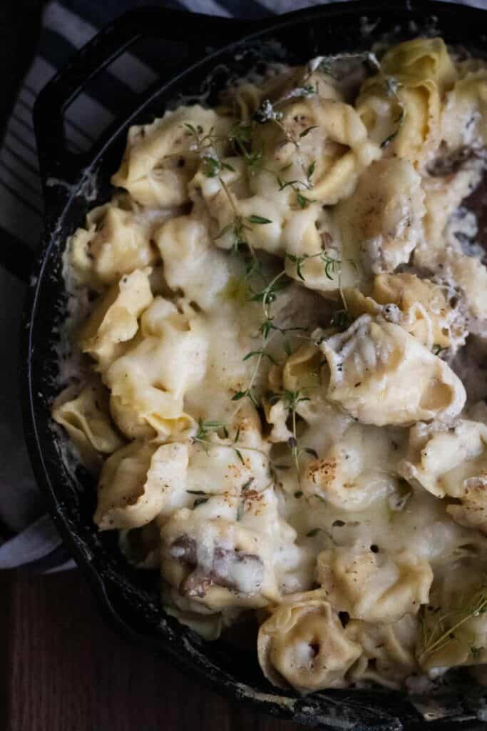 This is a picture of mushroom and ricotta cheese tortellini in a pan. 