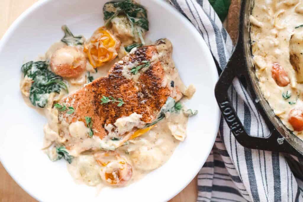 This is a picture of spinach and artichoke salmon on a plate.