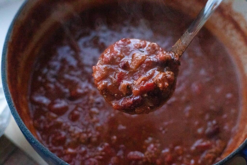 This is a scoop of chili in a ladle. 