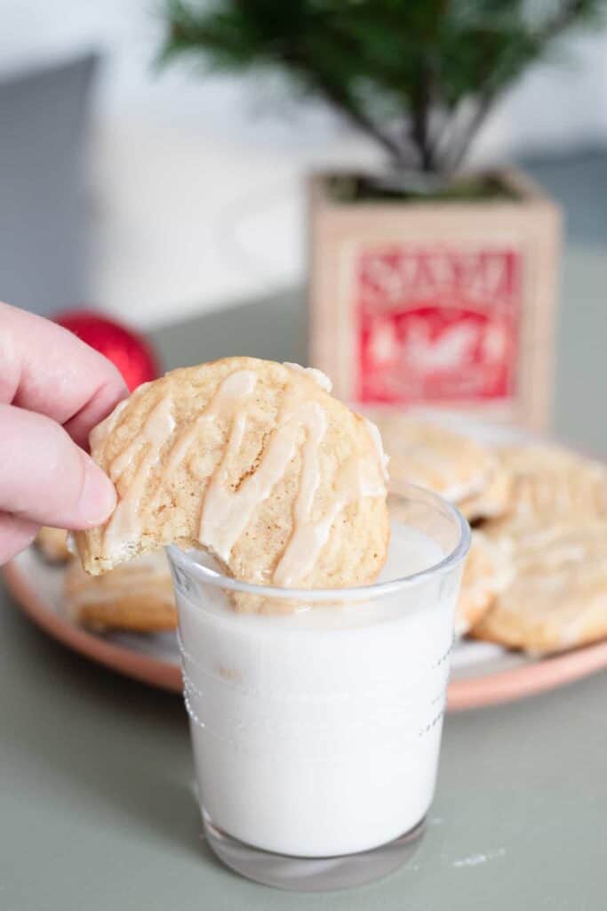 This is a picture of a vegan maple sugar cookie being dipped into almond milk.