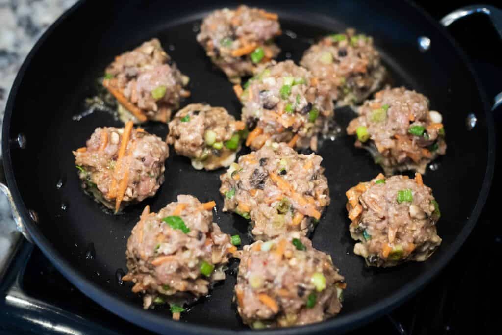 This is a picture of meatballs cooking in a pan. The Hangry Economist.