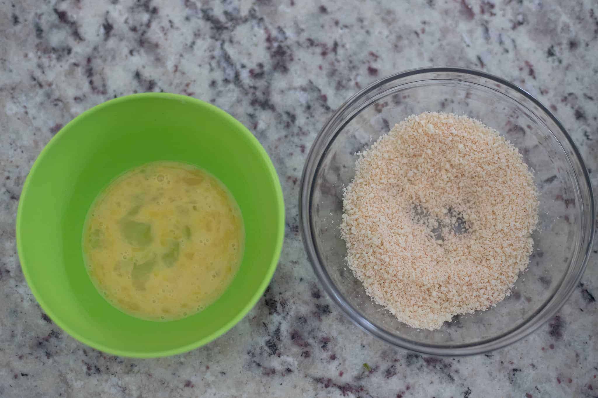 Two bowls, one with eggs and one with panko and parmesan cheese. The Hangry Economist.