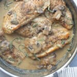 A pan of chicken breast with mushrooms and a creamy dijon sauce.