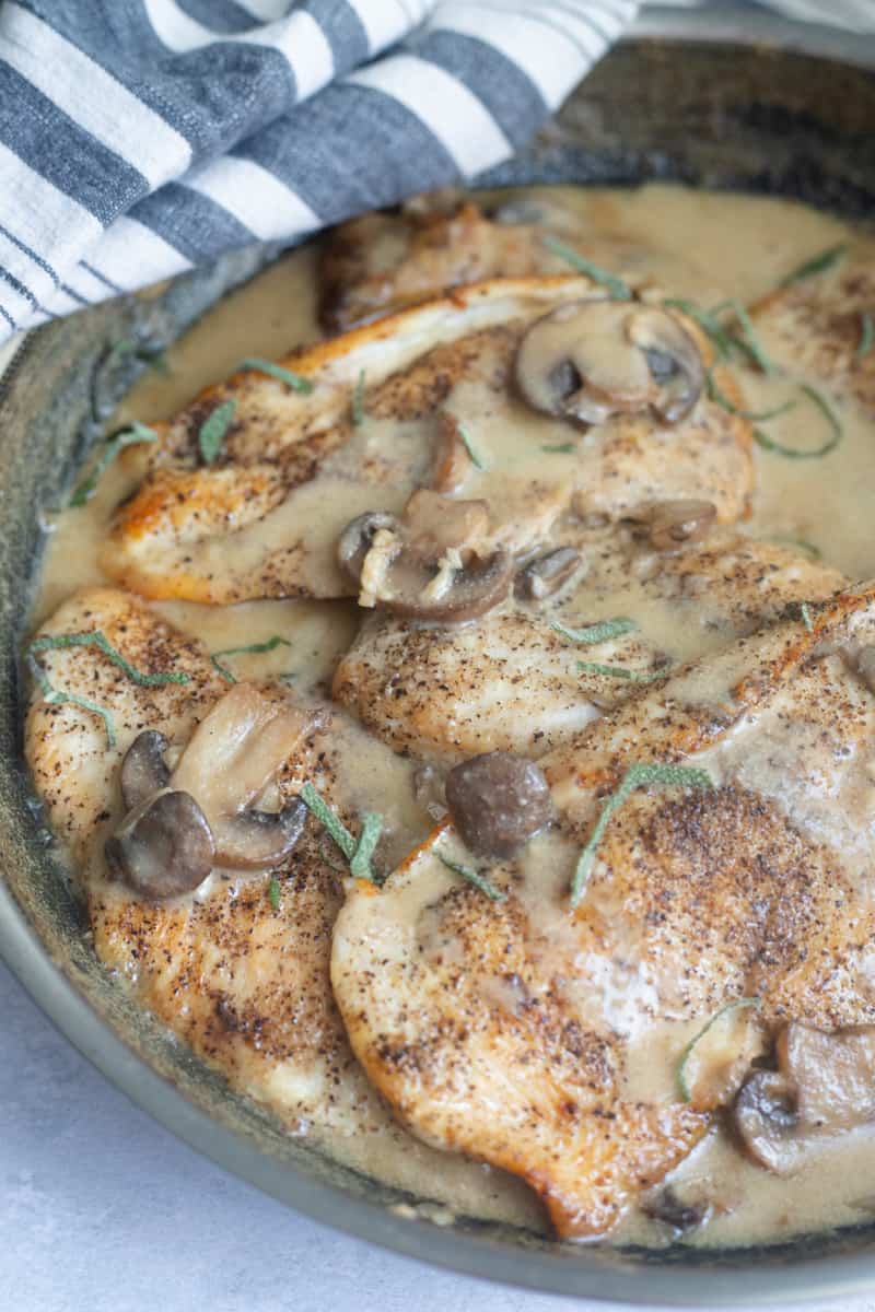 A pan of chicken breast with mushrooms and a creamy dijon sauce.
