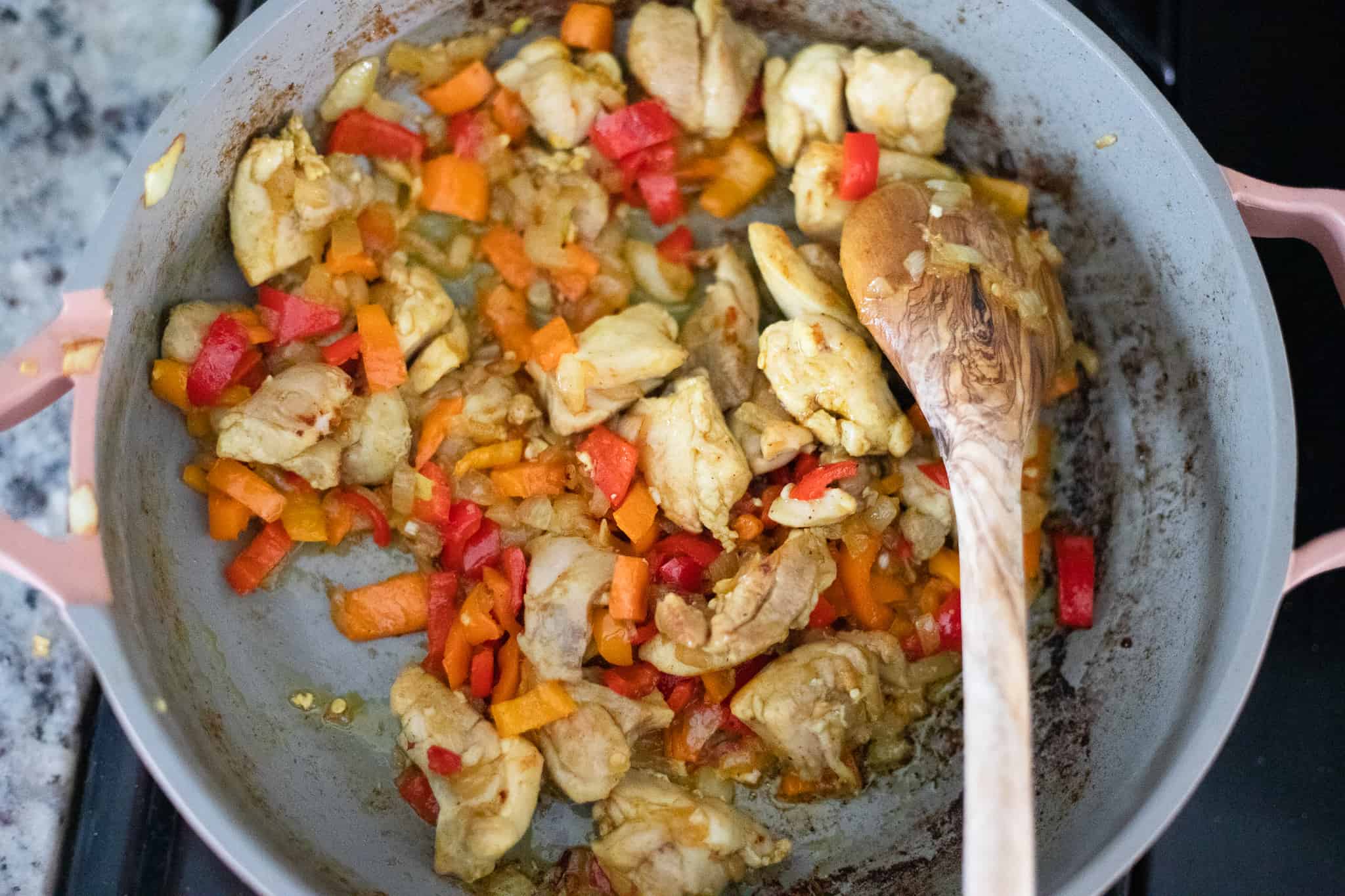 Peppers and chicken cooking in a pan. The Hangry Economist.