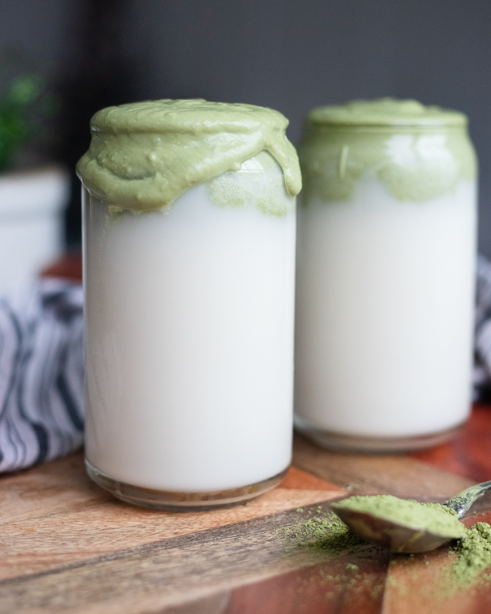 Two cups of milk topped with whipped matcha.