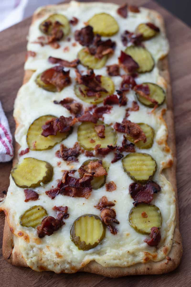Cooked flatbread with pickles and bacon. 