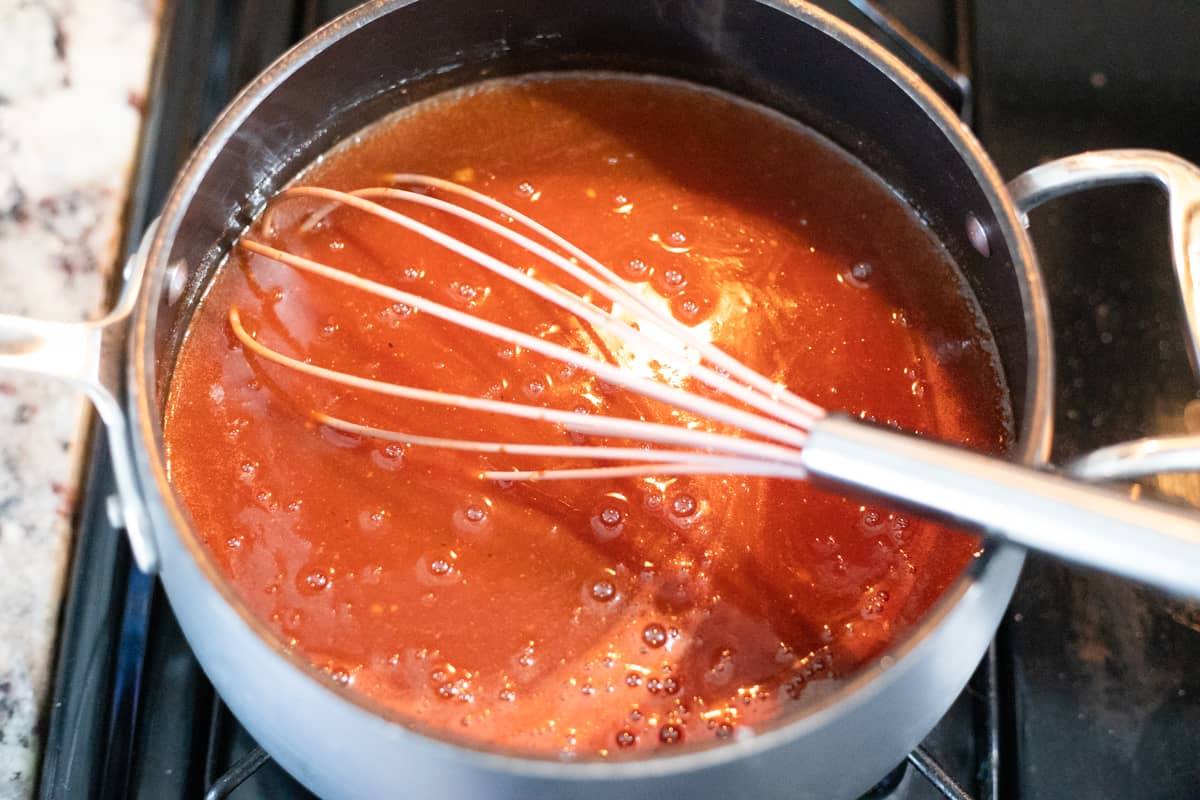Apple cider bbq sauce ingredients mixed together in a saucepan.