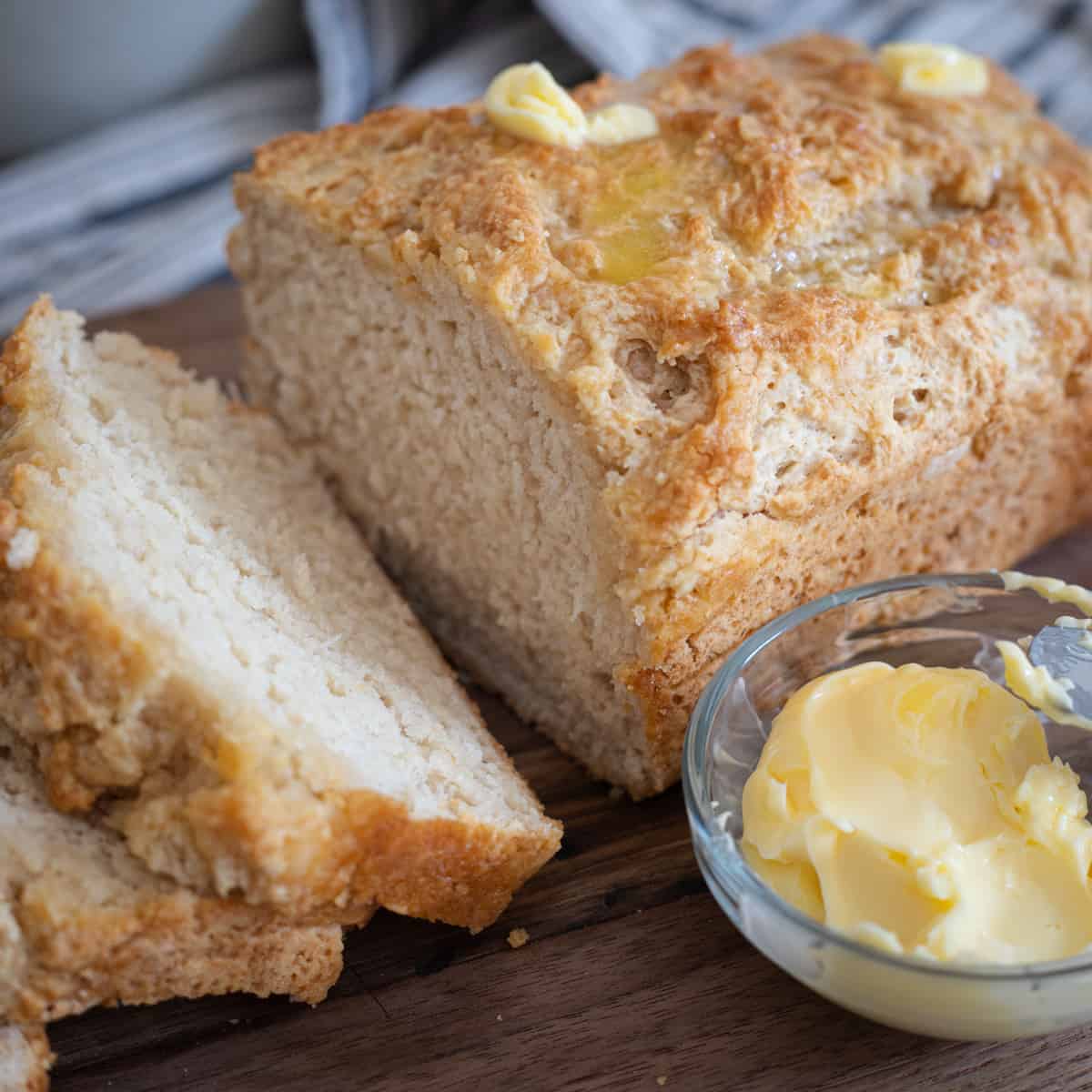 Beer bread on a cutting board with butter. 