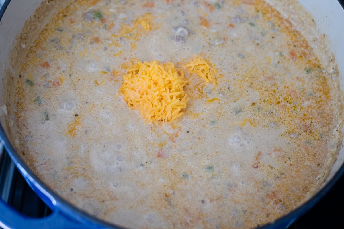 Cheese being mixed into cheeseburger soup. 