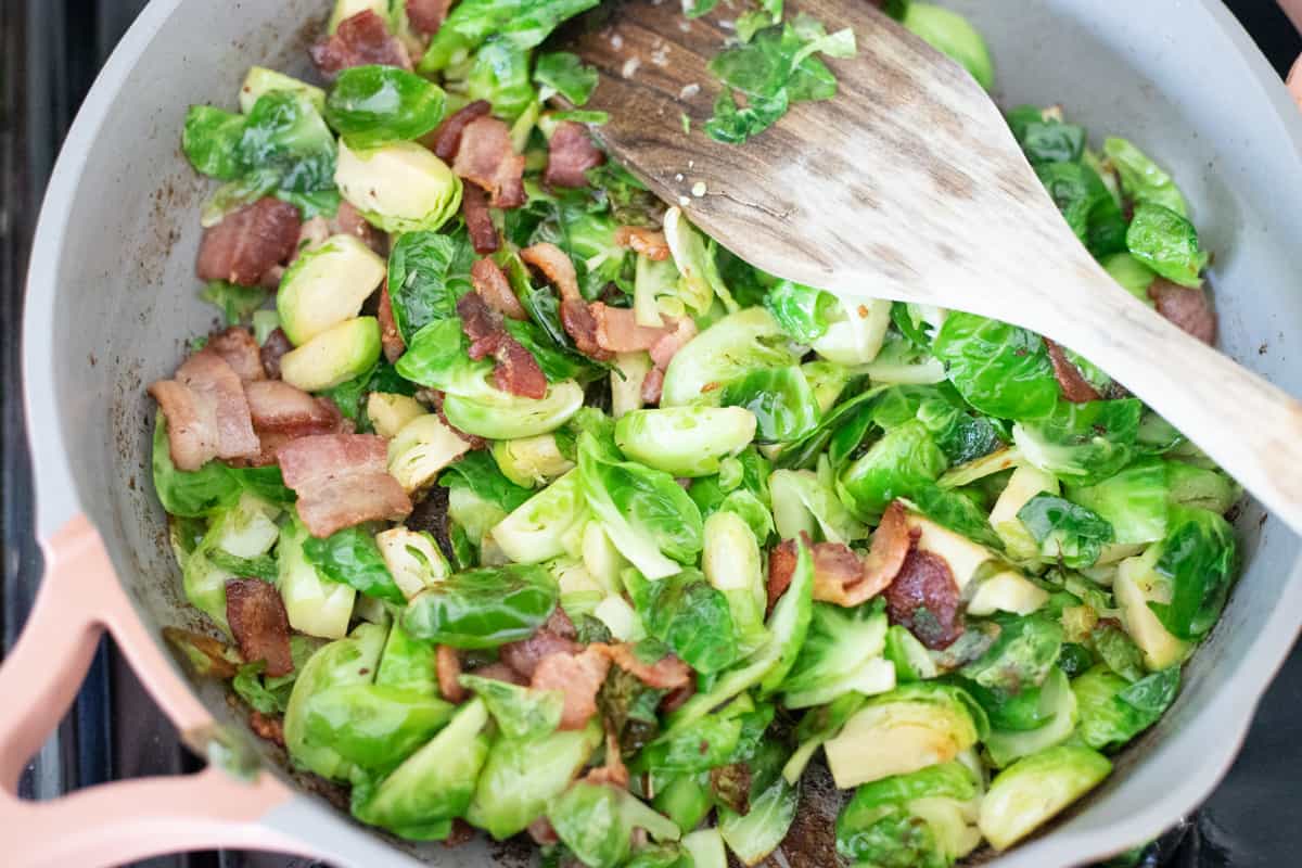 Brussels sprouts and bacon cooking in a pan. 
