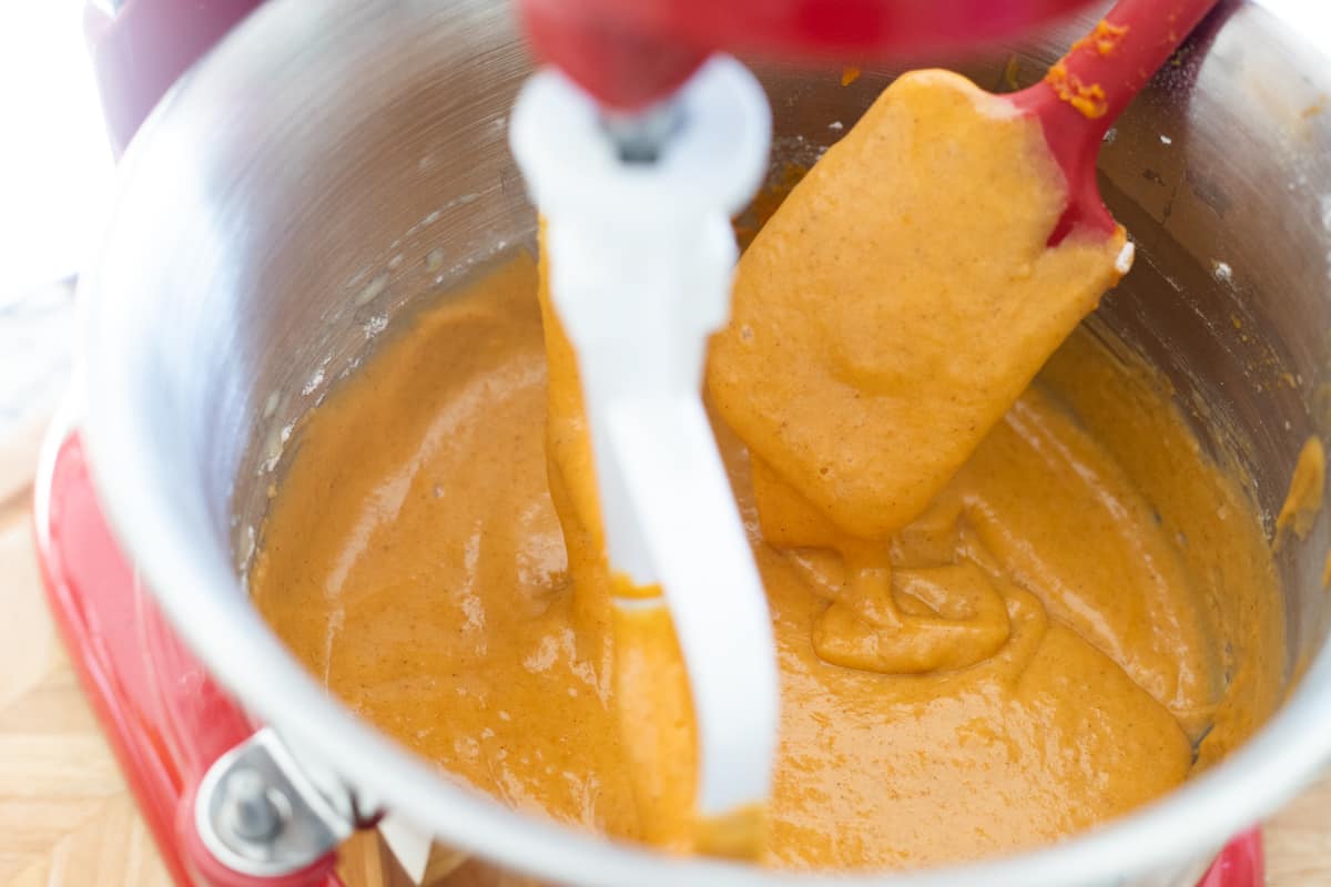 Pumpkin cake batter in the mixing bowl of a stand mixer. 