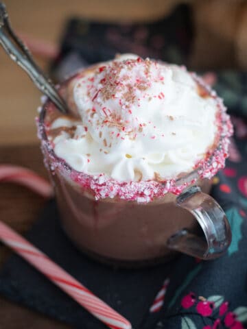 Dairy-free hot chocolate in a mug topped with whipped cream and peppermint.
