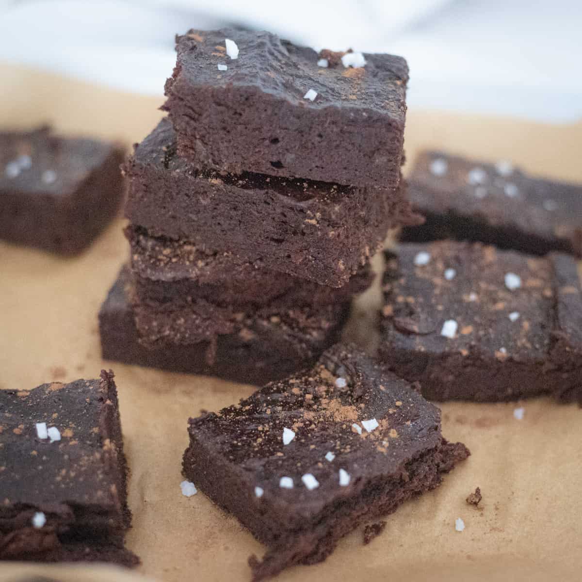A stack of date brownies topped with flakey sea salt. 