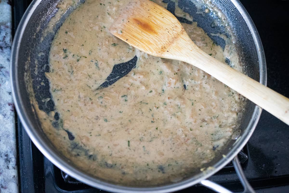 Thickened creamy dijon sauce in a pan.