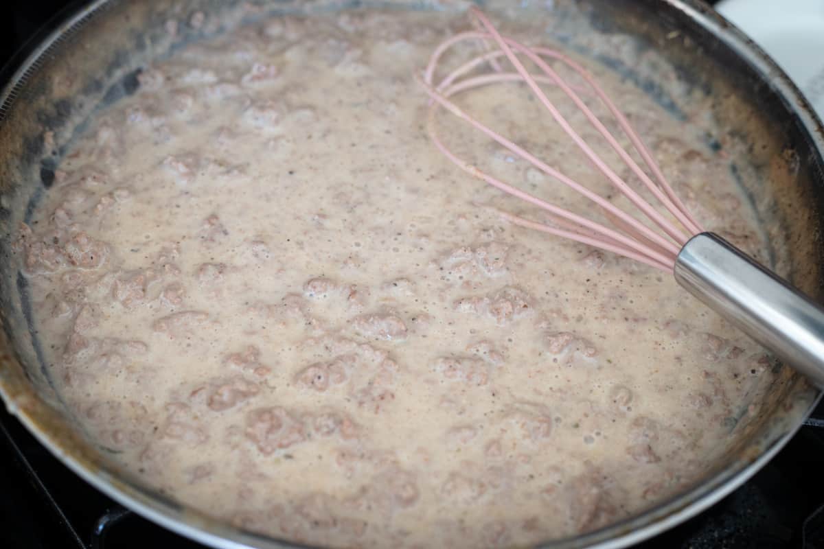 Ground meat and gravy cooking in a pan.