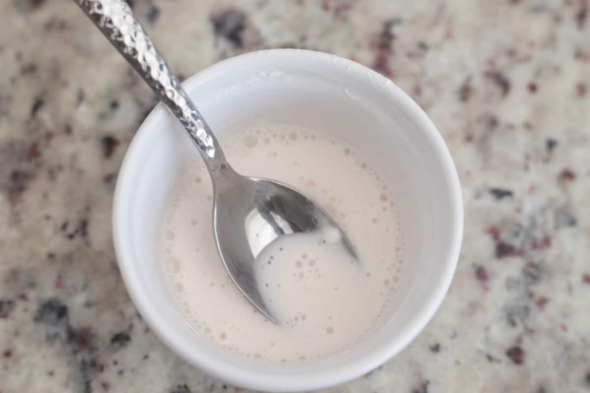 Arrowroot powder and almond milk mixed together in a bowl. 