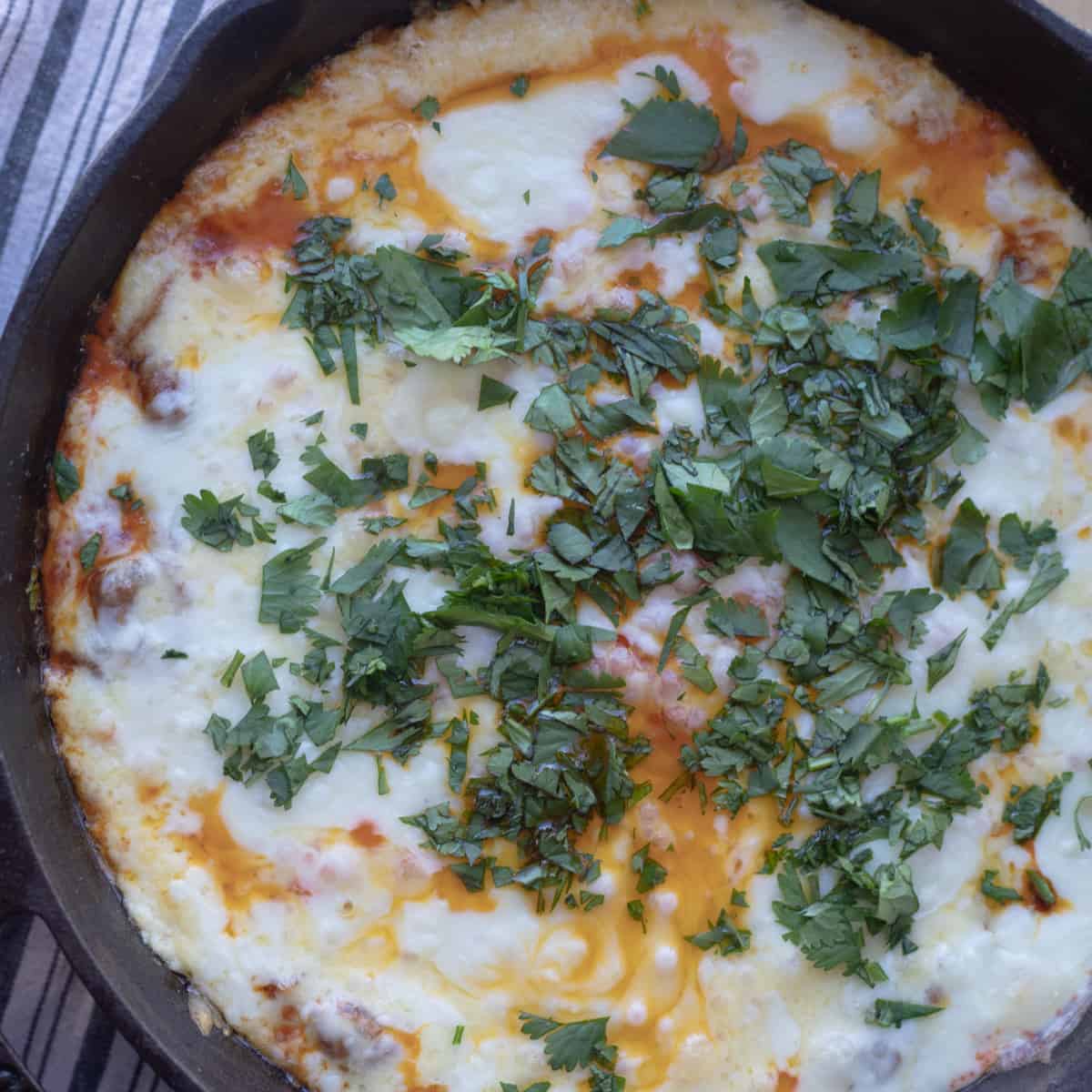 A cast-iron pan filled with chorizo queso fundido. 