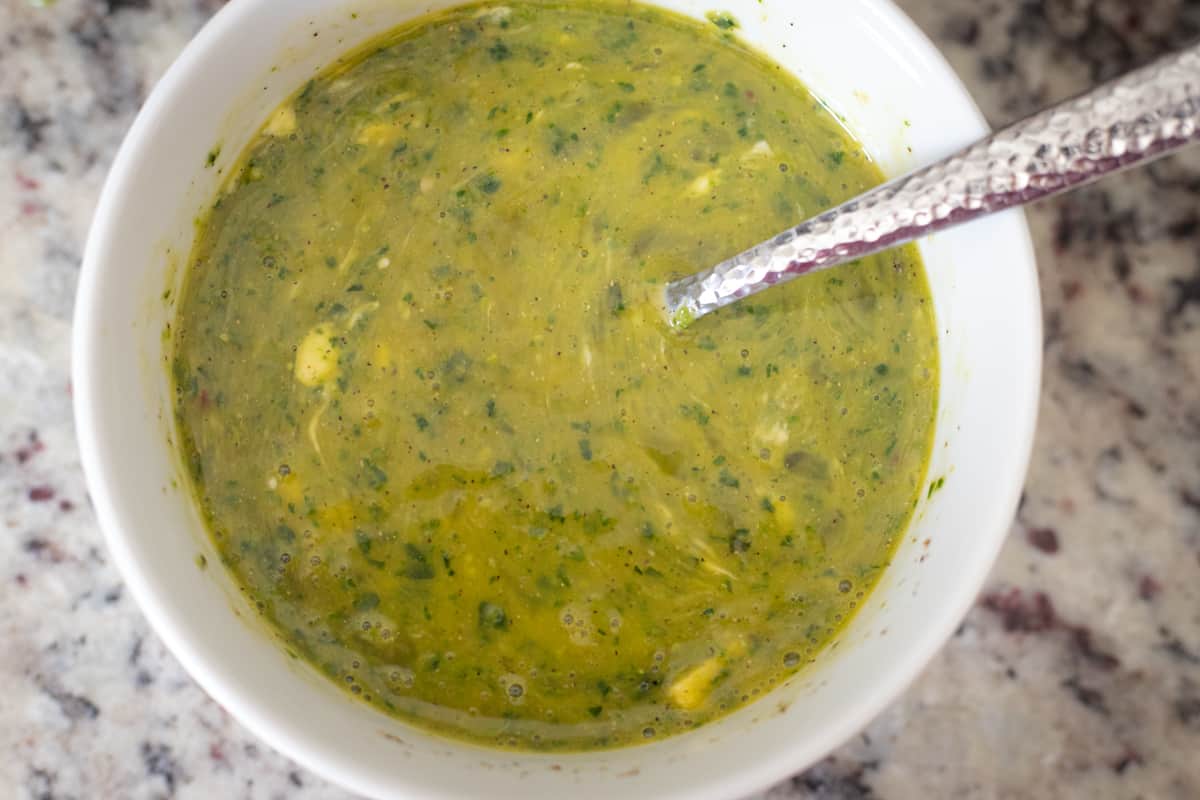 Scrambled pesto egg ingredients mixed together in a bowl. 