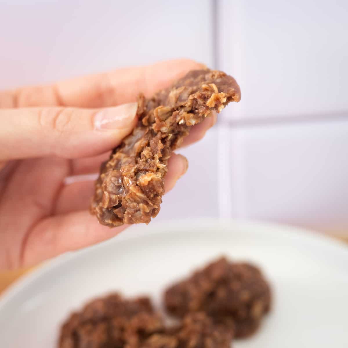 A hand holding a nut-free no-bake cookie with a bite out of it. 