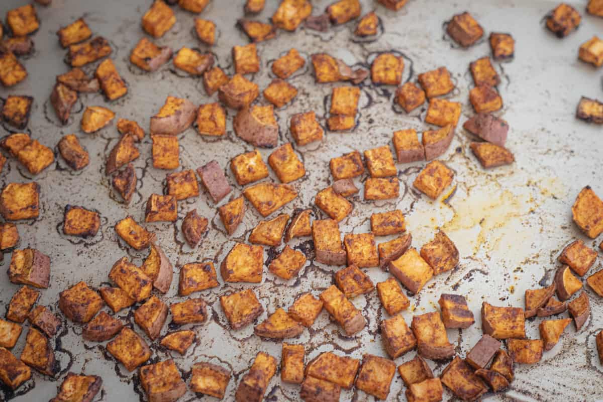 Cooked cubed sweet potatoes on a sheet pan. 