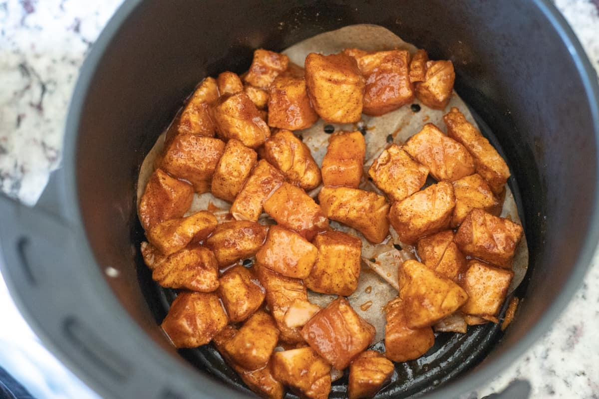 Salmon bites in an air fryer basket. 