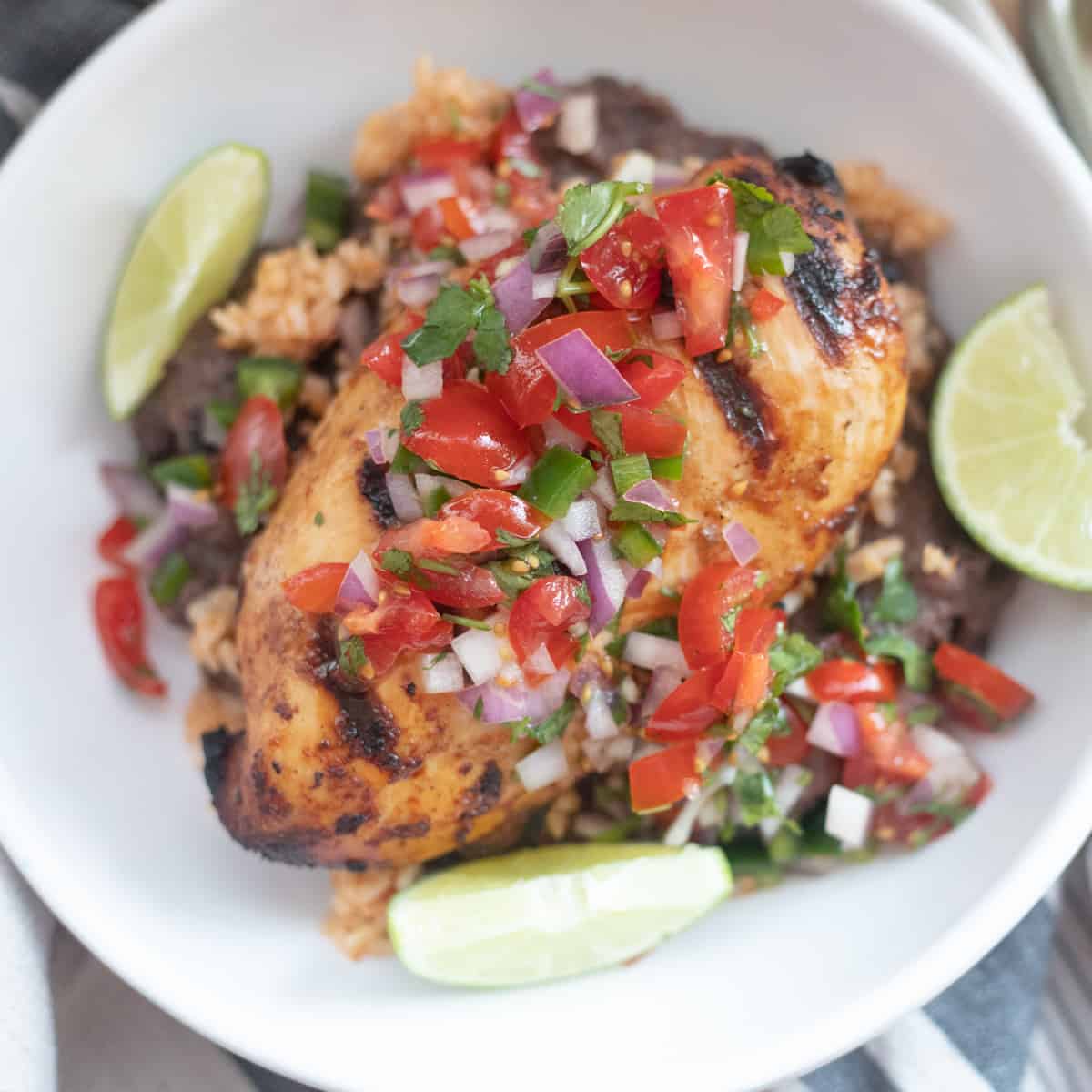 Grilled margarita chicken in a bowl topped with pico de gallo. 