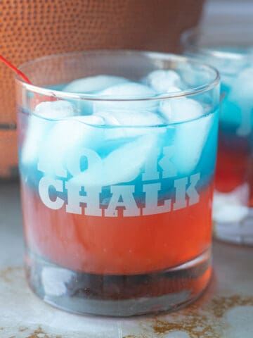A blue and red Jayhawk cocktail sitting in front of a basketball.