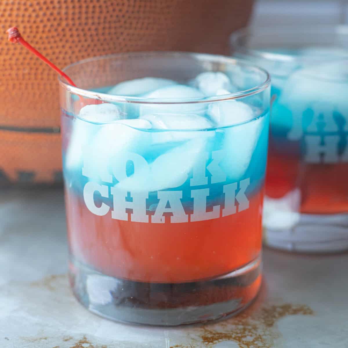 A blue and red Jayhawk cocktail sitting in front of a basketball.