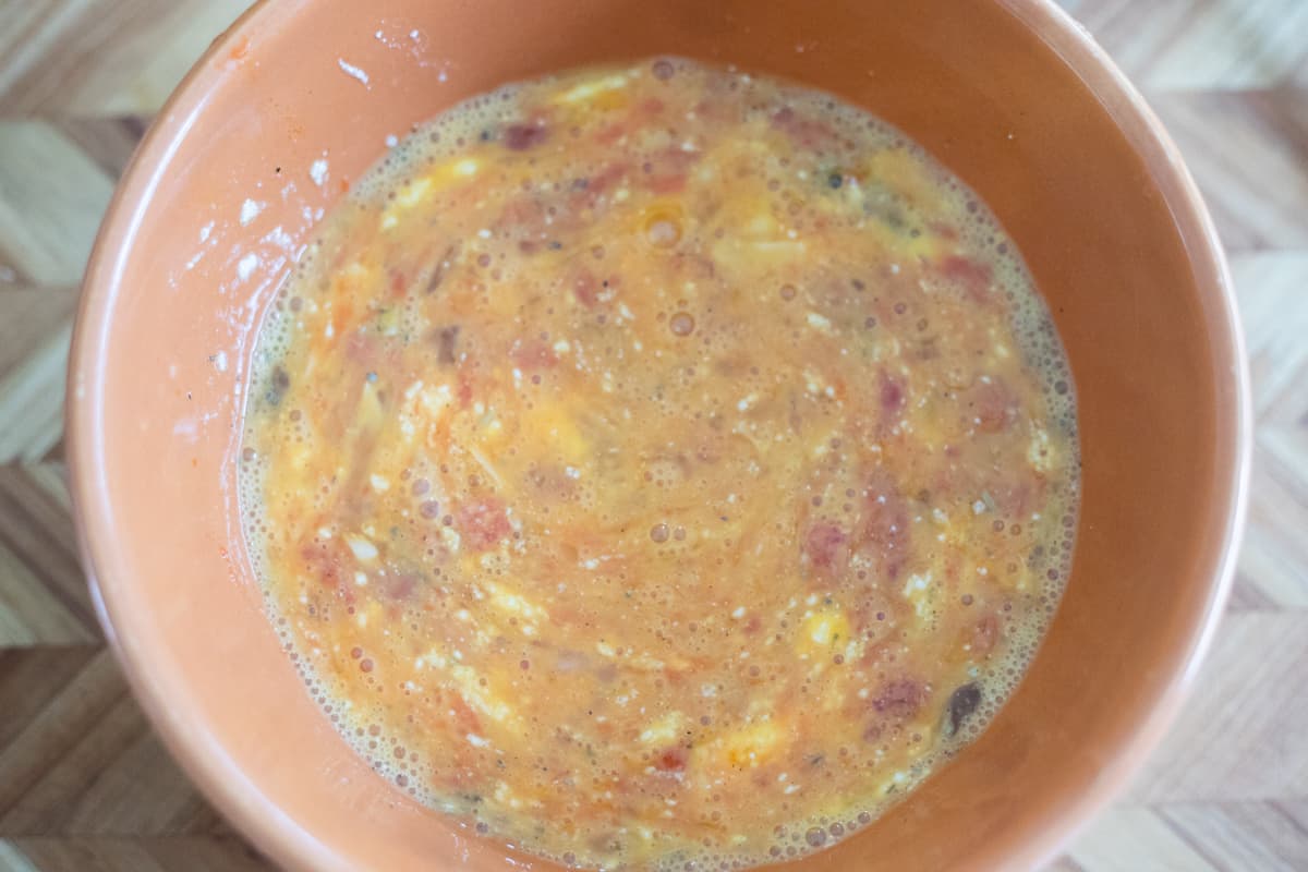 Eggs, marinara sauce, cheese, seasonings, and pepperoni in a mixing bowl. 