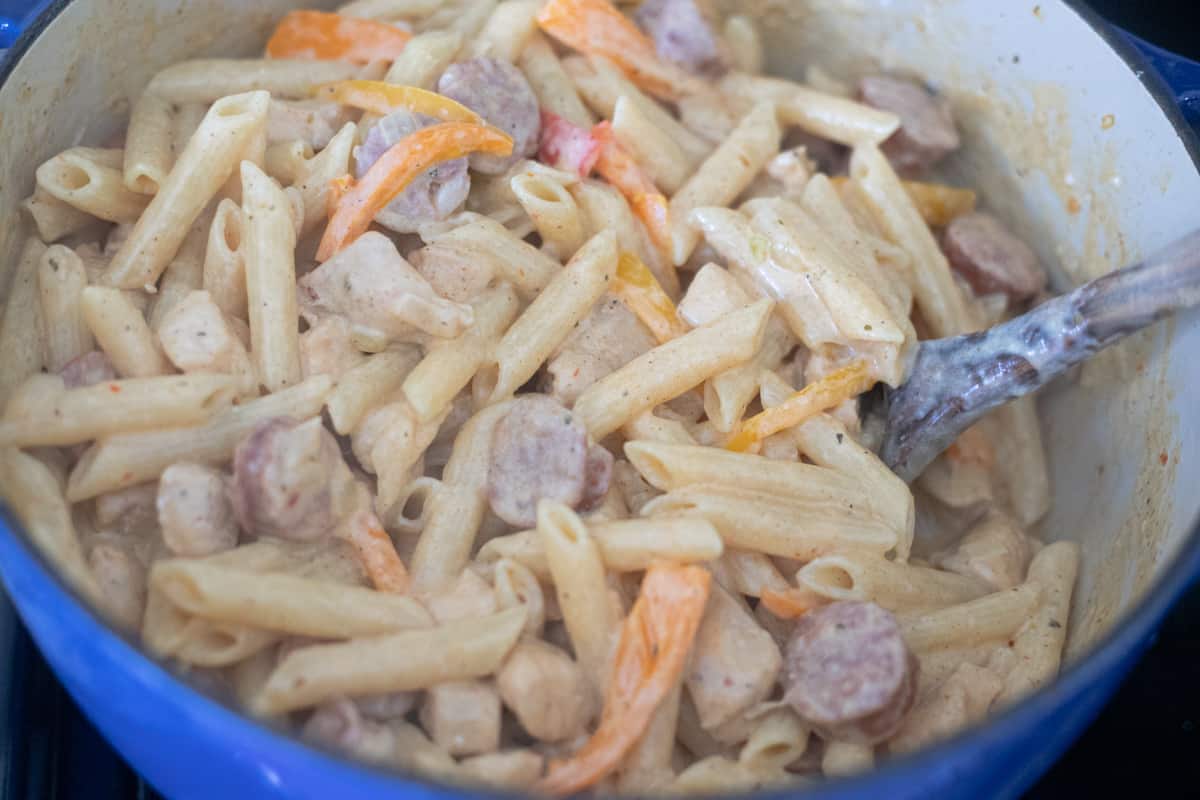 Finished one-pot cajun chicken pasta in a dutch oven. Everything is melted and creamy. 
