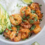 Cooked frozen shrimp in a serving bowl topped with cilantro.