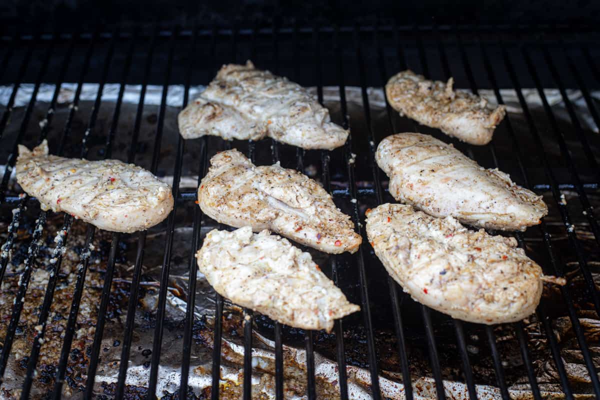 Chicken breasts cooking on a grill. 
