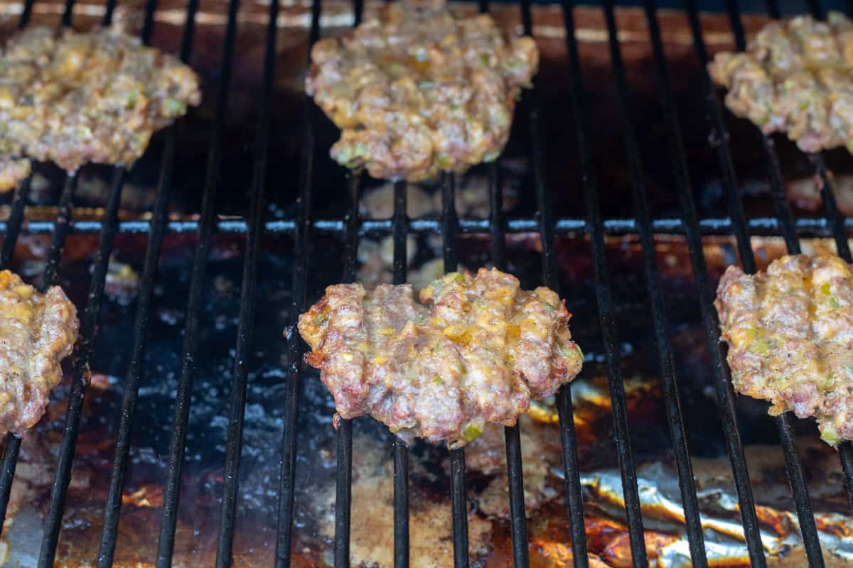 Burgers cooking on a grill. 