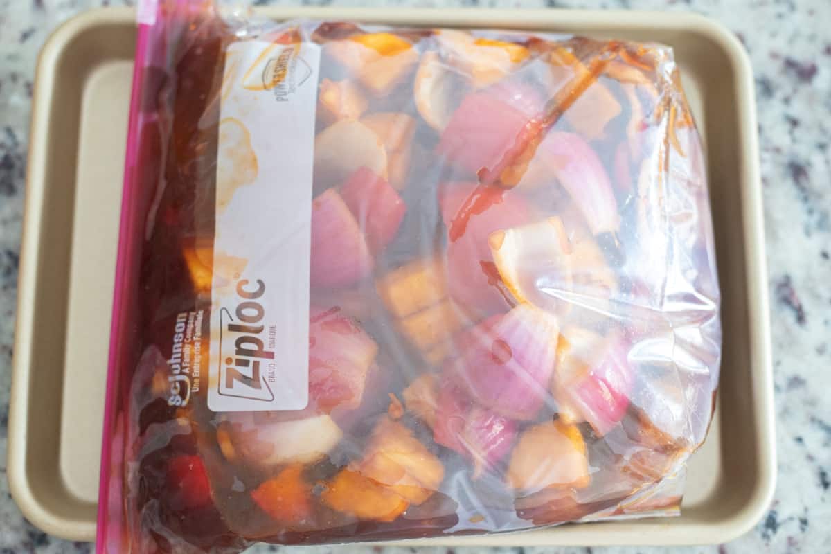 Chicken, red onions, pineapple, and red peppers in a gallon plastic baggie with marinade. 