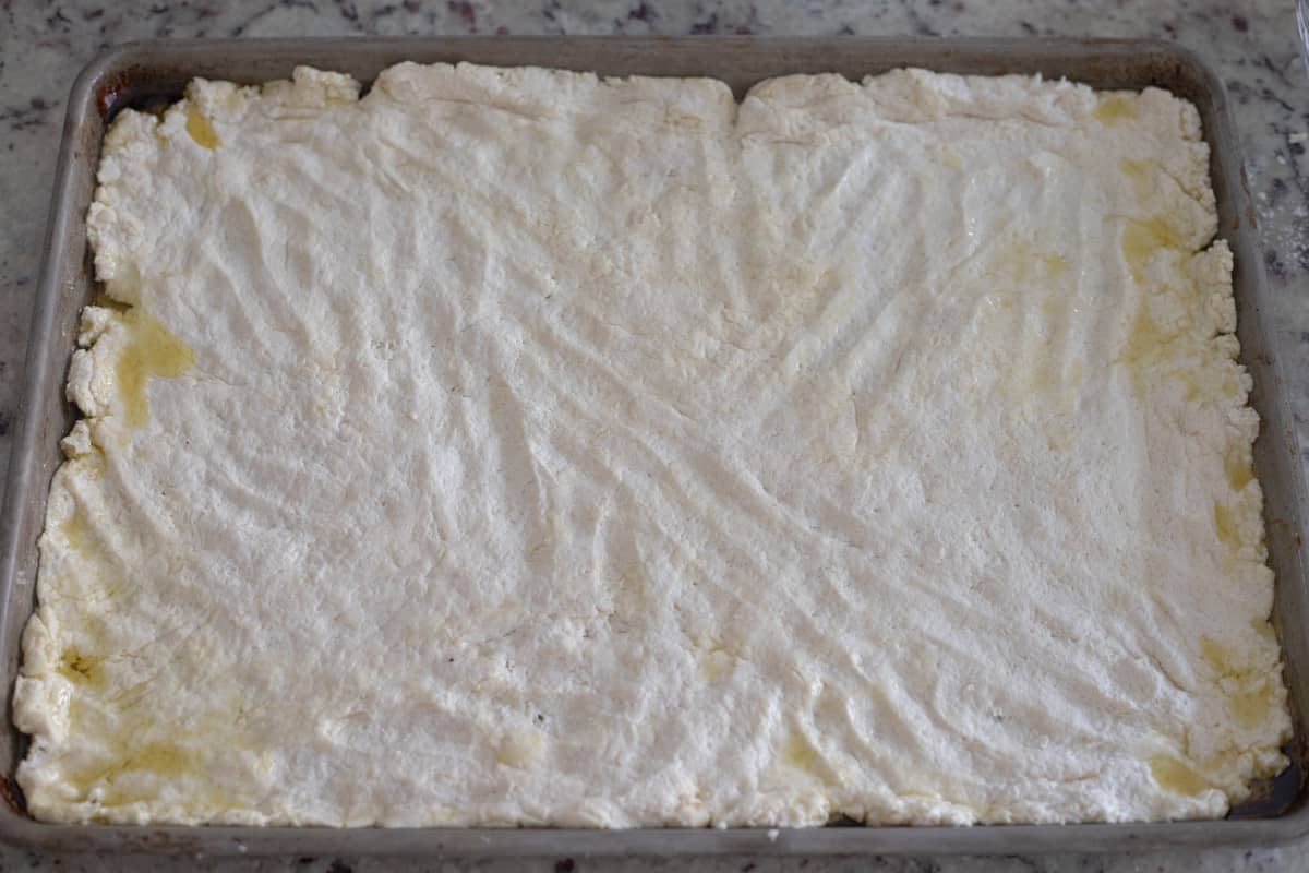 Dough spread out on a sheet pan. 