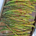 Grilled asparagus on a baking sheet.