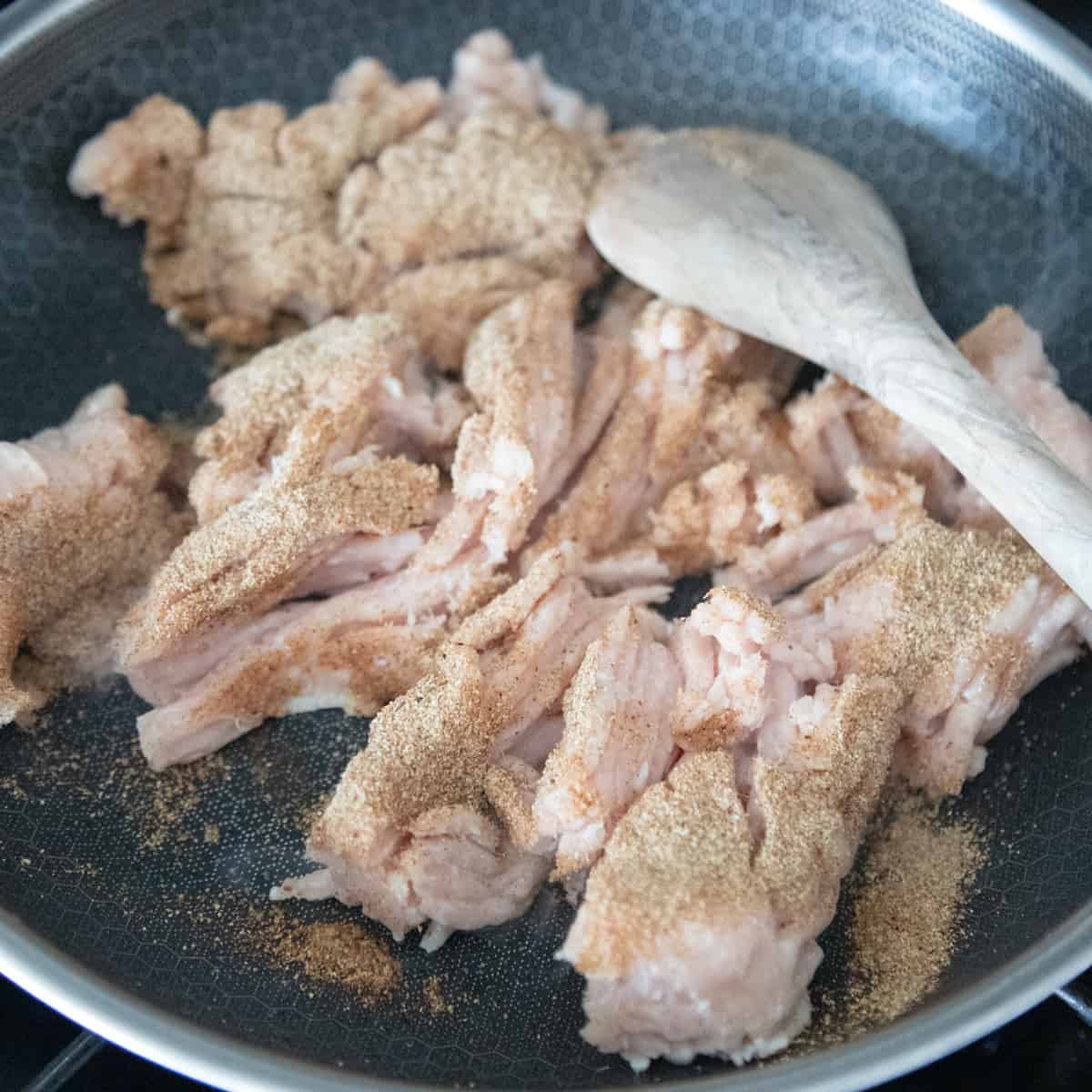 Ground chicken and spices cooking in a pan. 