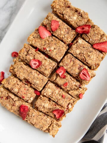 A serving dish of strawberry protein bars topped with freeze dried strawberries.