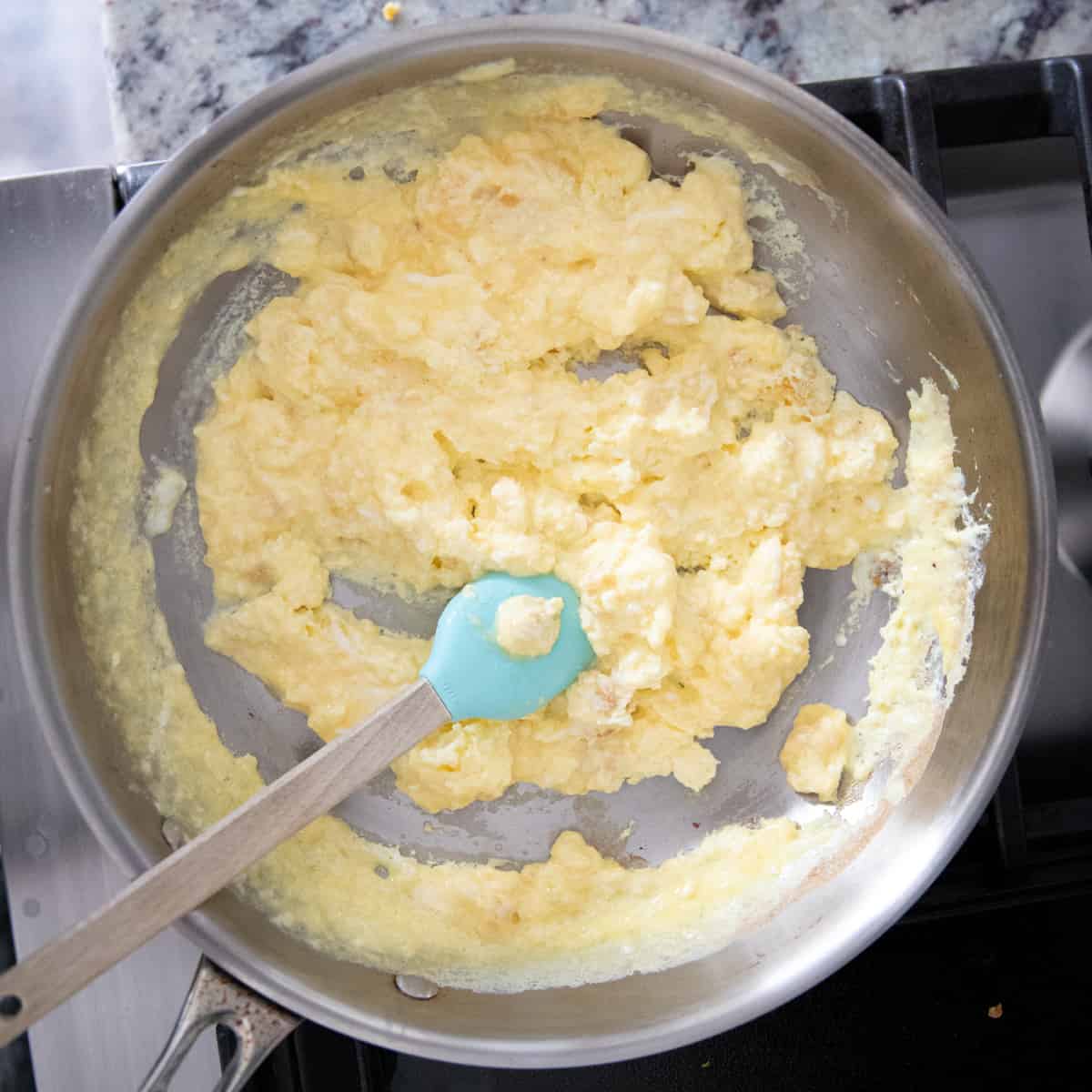 Cooked scrambled eggs in a pan. 