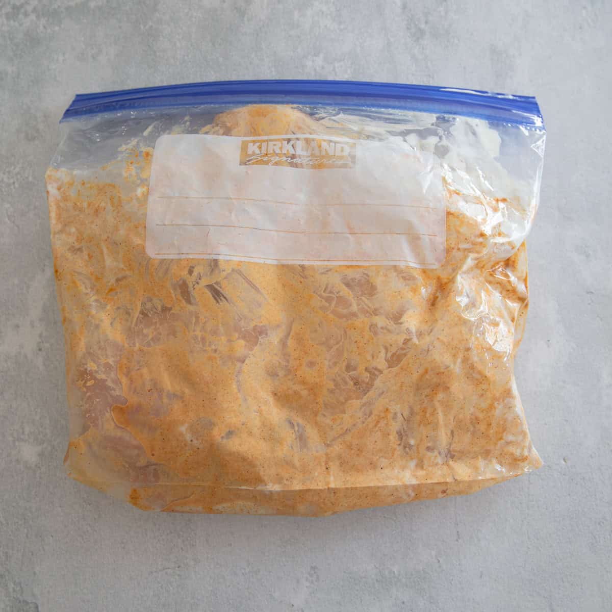 Chicken breasts in a baggie with seasonings and yogurt. 