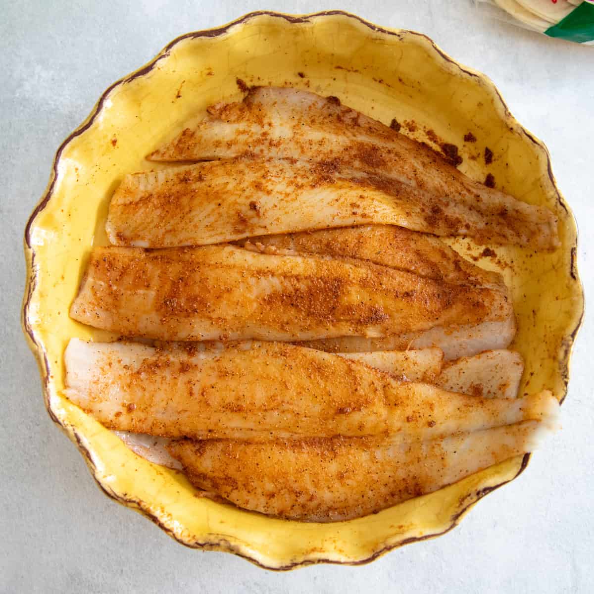 Flounder fillets coated in oil and spices.